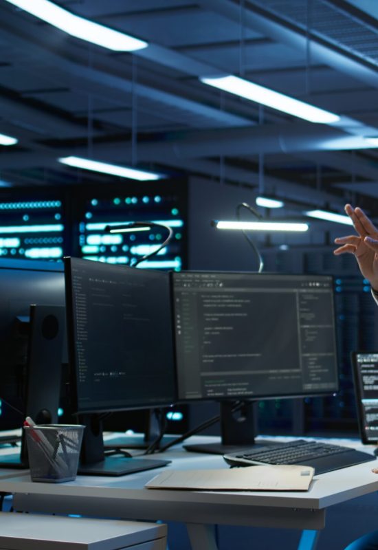 Data center admin responsible for installation of networking systems wearing high tech VR headset. IT worker doing maintenance on server farm gear using virtual reality technology, camera B